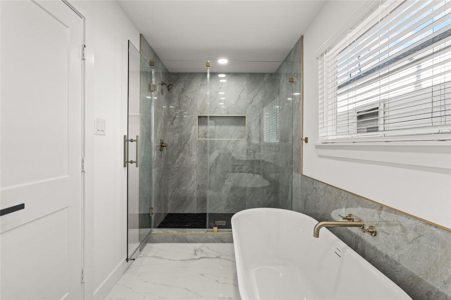 Detail-driven design. From the sleek chevron-patterned shower floor to the seamless glass enclosure, no expense was spared in crafting this sanctuary.
