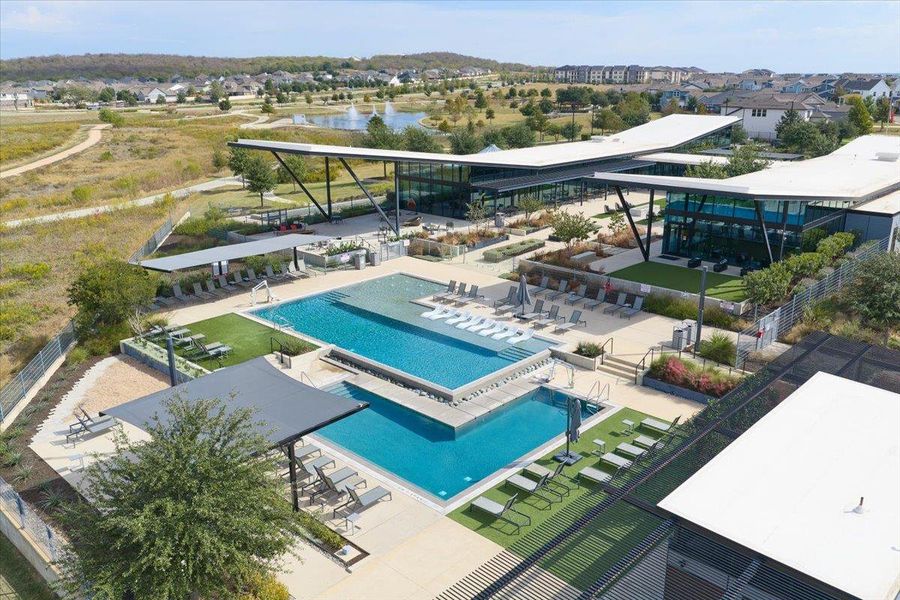 Aerial view of residential area with a pool area and a nearby body of water Aerial view of residential area with a pool area and a nearby body of water