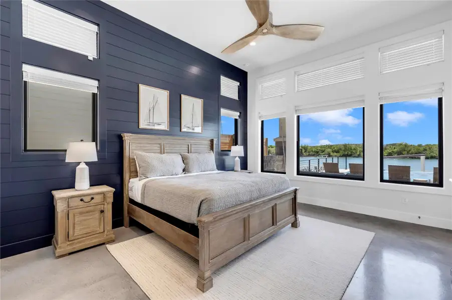 Primary Bedroom on main. High ceilings and generous windows frame tranquil waterfront views from this primary suite.