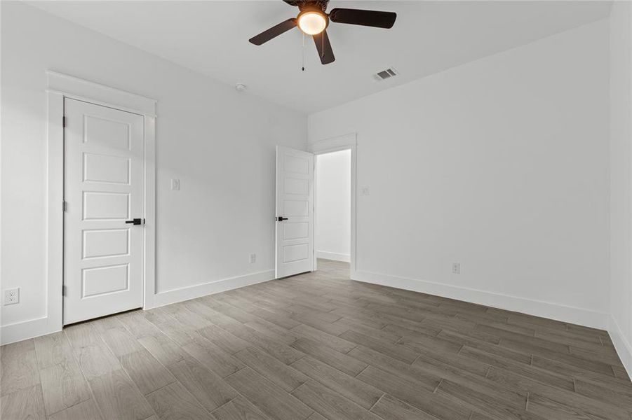 Empty room with wood-type flooring and ceiling fan