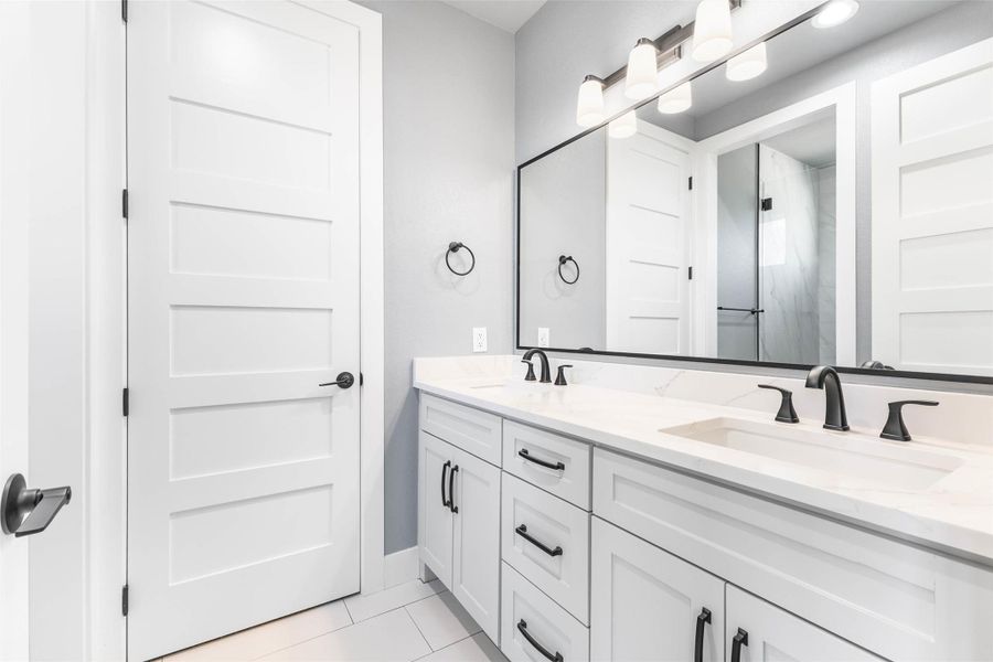 Bathroom featuring double vanity and light tile patterned flooring Bathroom featuring double vanity and light tile patterned flooring
