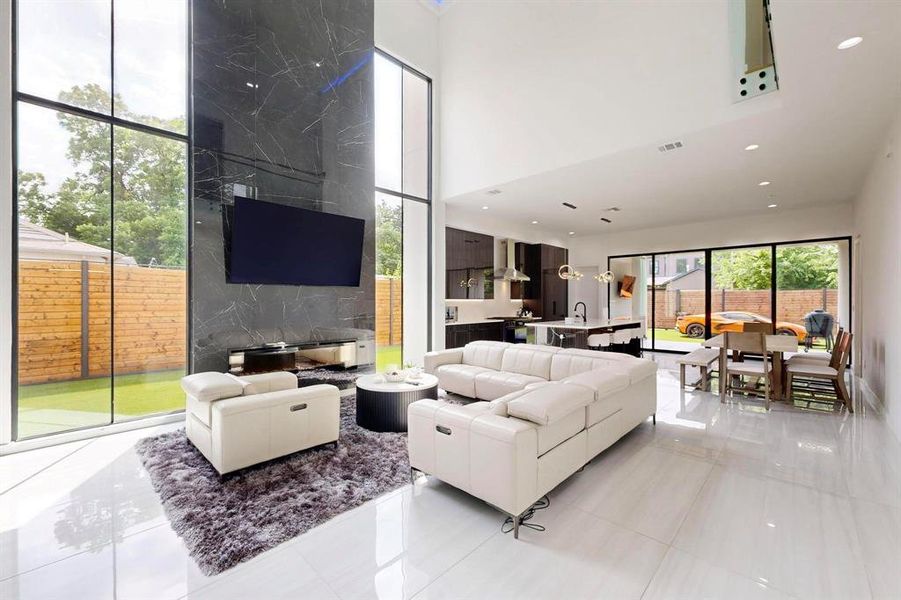 Living room with a high ceiling, light tile patterned floors, and recessed lighting Living room with a high ceiling, light tile patterned floors, and recessed lighting