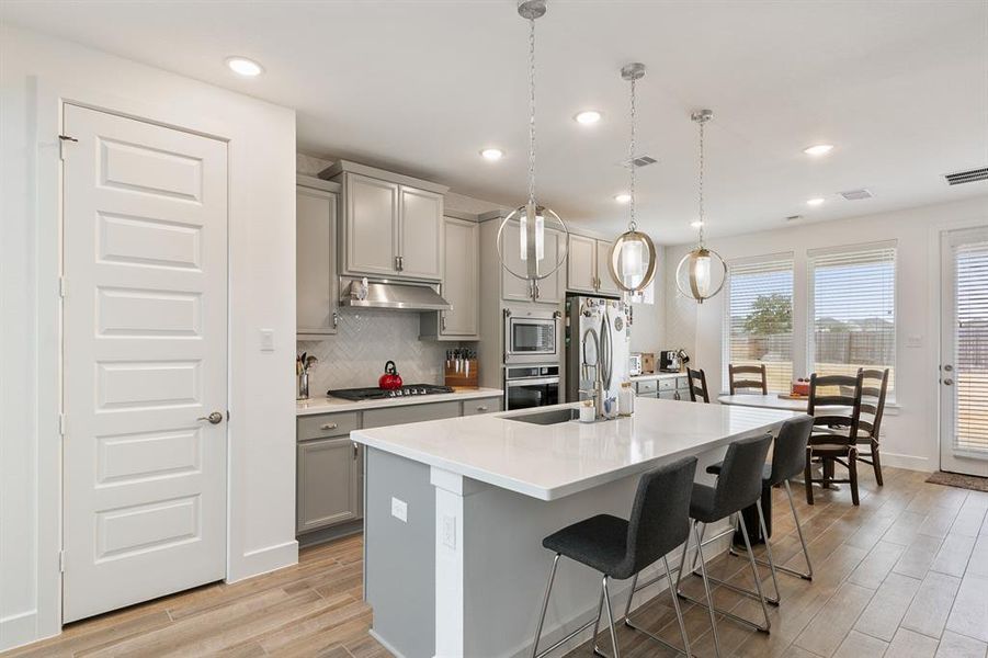 Stylish pendant lights add elegance and charm to the kitchen.