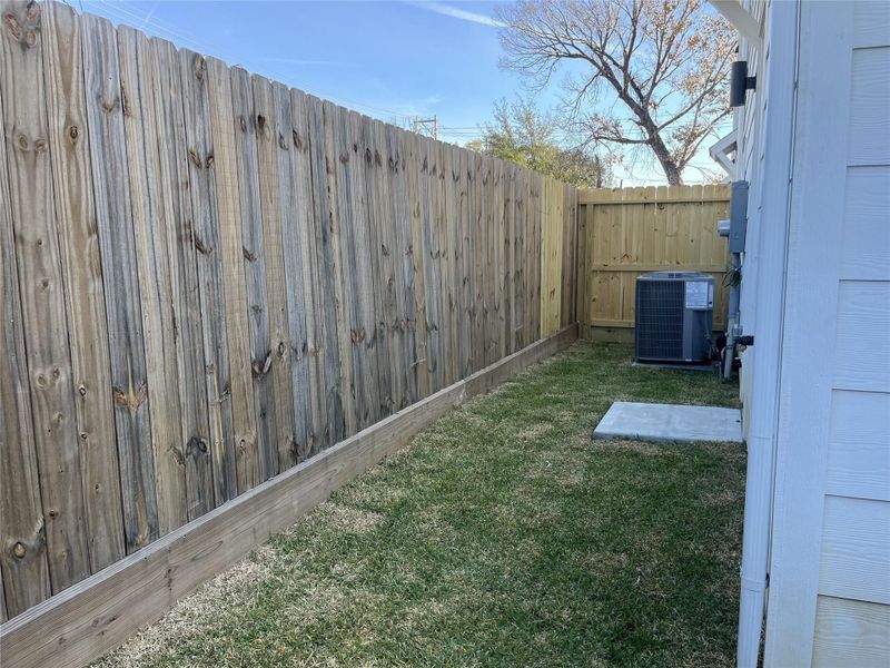 This cozy backyard patio offers a charming outdoor retreat, accessible directly from the secondary bedroom and through a wooden gate that leads to the driveway, providing convenient indoor-outdoor flow and added privacy.