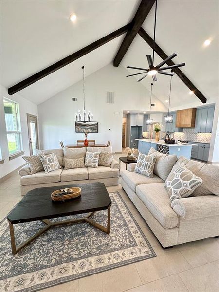 Living room featuring beam ceiling, light tile patterned floors, a chandelier, high vaulted ceiling, and recessed lighting