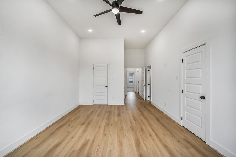 Spacious primary bedroom featuring soaring ceilings, modern finishes, and a bright feel.