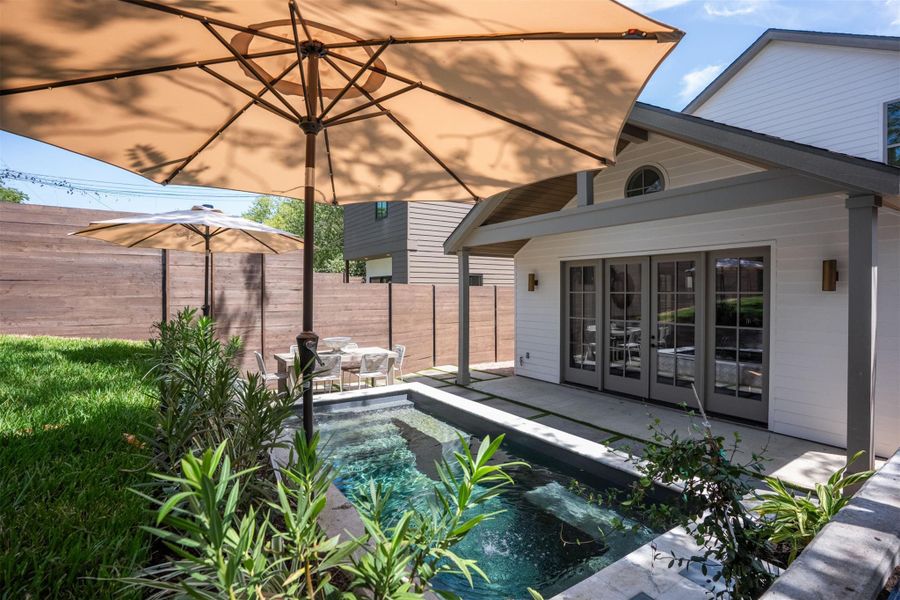 An inviting plunge pool anchors this private backyard patio beneath a covered porch. An inviting plunge pool anchors this private backyard patio beneath a covered porch.
