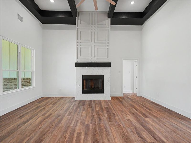 Spacious interior featuring high ceilings with dark contrasting beams and recessed lighting