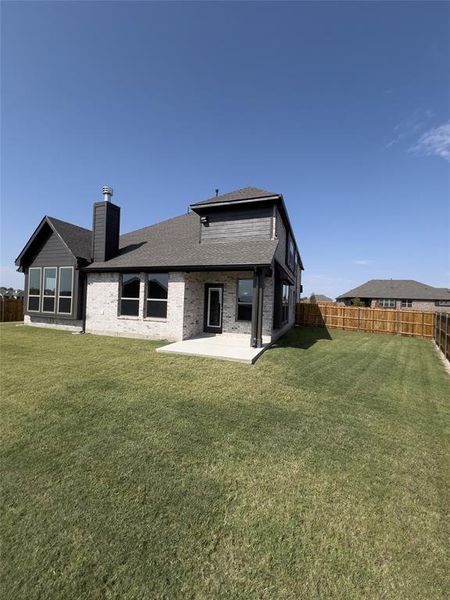 Back of house with a yard and a patio area