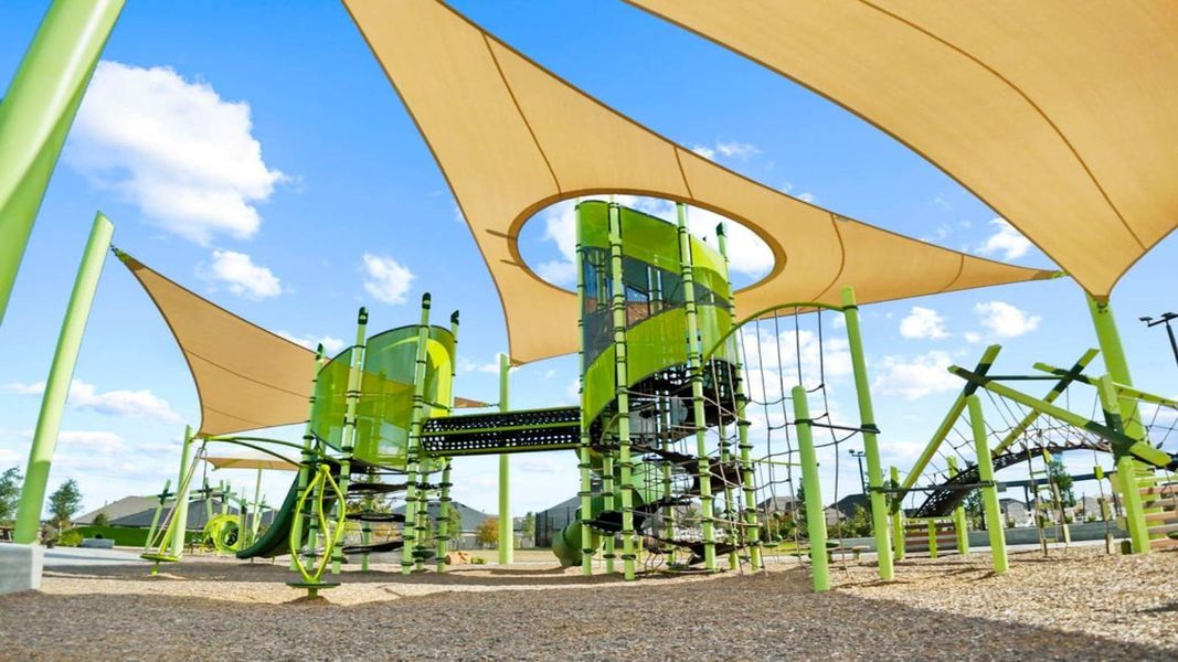Community playground with swings, slides, and a shaded seating area surrounded by green space Community playground with swings, slides, and a shaded seating area surrounded by green space