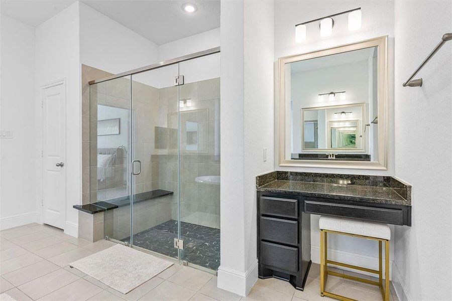 Primary bath boasts separate vanity sinks a nice sized garden tub, a make up vanity, large standing shower with bench, and wonderful natural light.