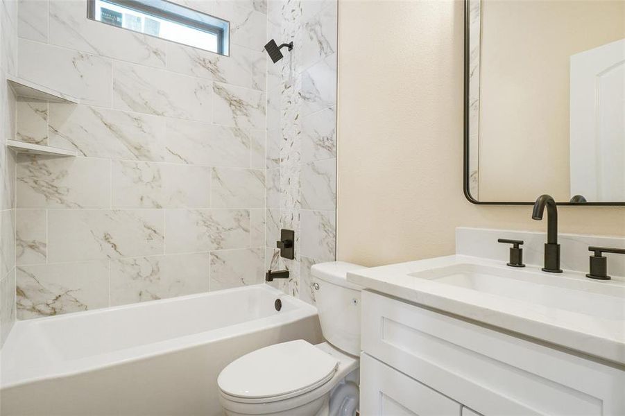 Full bathroom featuring vanity, toilet, and tiled shower / bath combo