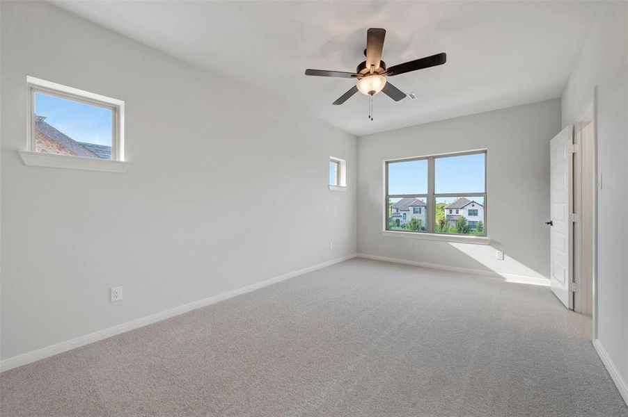 Spacious room featuring light gray carpeting and neutral wall paint