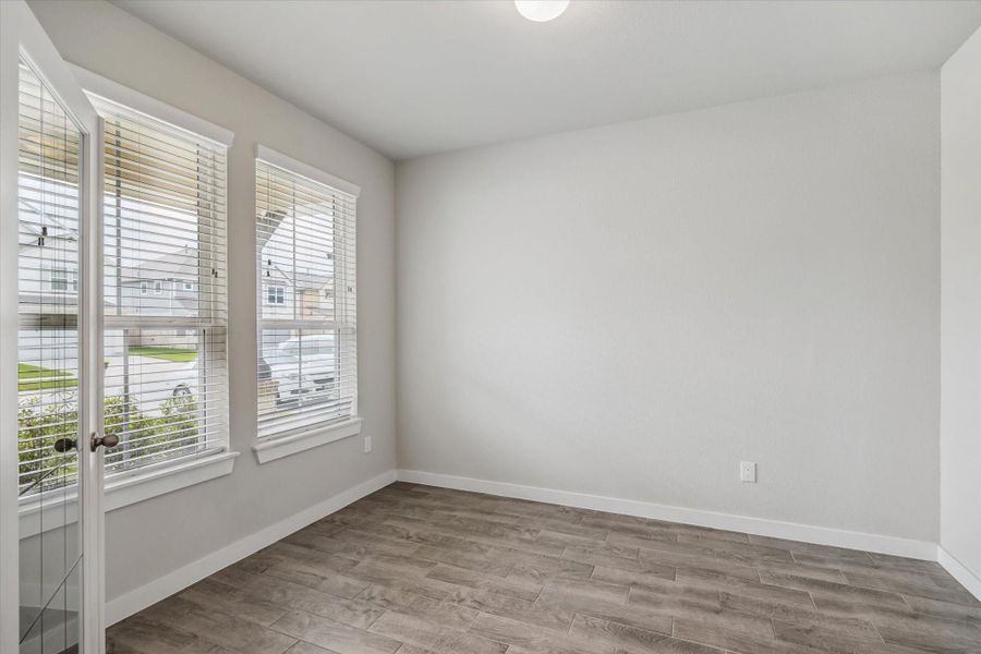 Bright and airy room with large windows, light-colored walls, and wood-look flooring. Ideal for a home office or cozy sitting area. Bright and airy room with large windows, light-colored walls, and wood-look flooring. Ideal for a home office or cozy sitting area.
