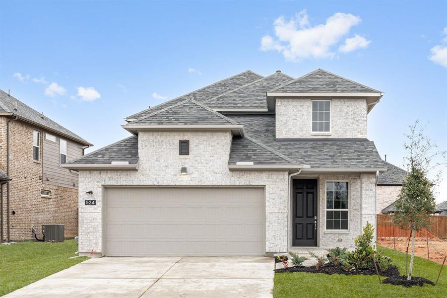 French country style house with a garage, driveway, roof with shingles, cooling unit, and brick siding