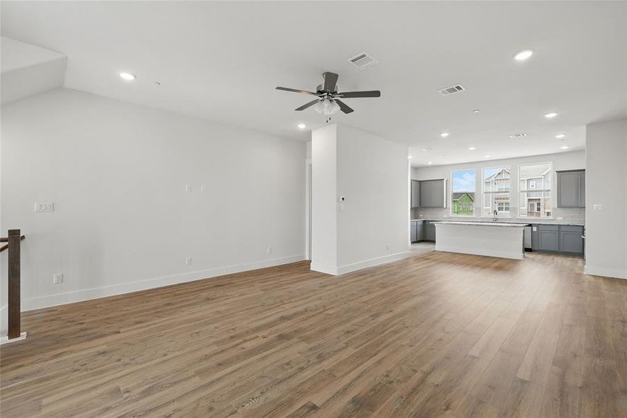 Unfurnished living room featuring light wood-style flooring, a ceiling fan, and recessed lighting