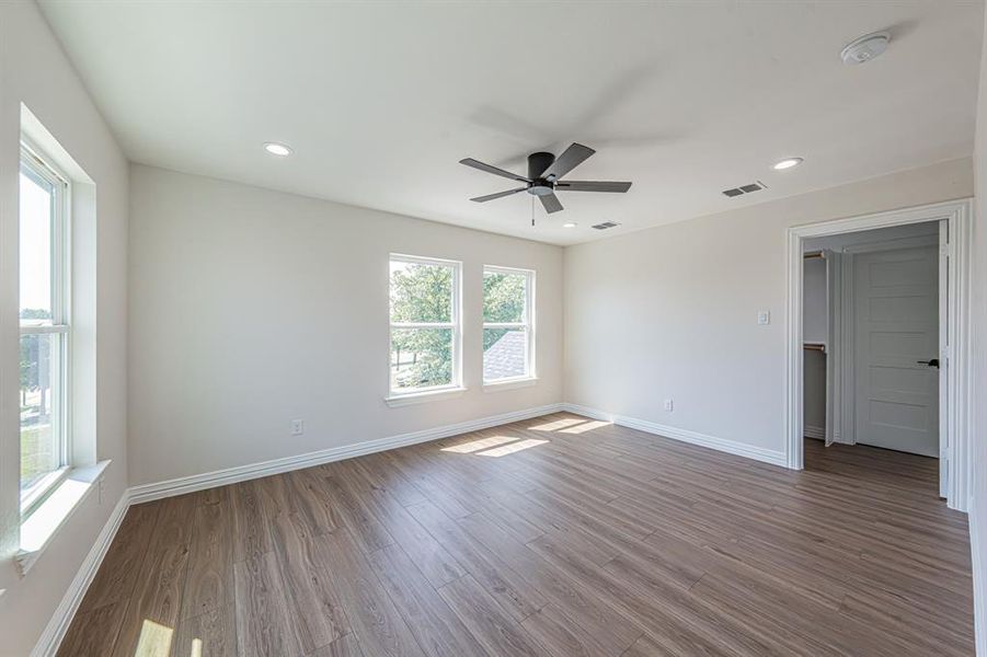 Empty room with wood finished floors, recessed lighting, and a ceiling fan Empty room with wood finished floors, recessed lighting, and a ceiling fan