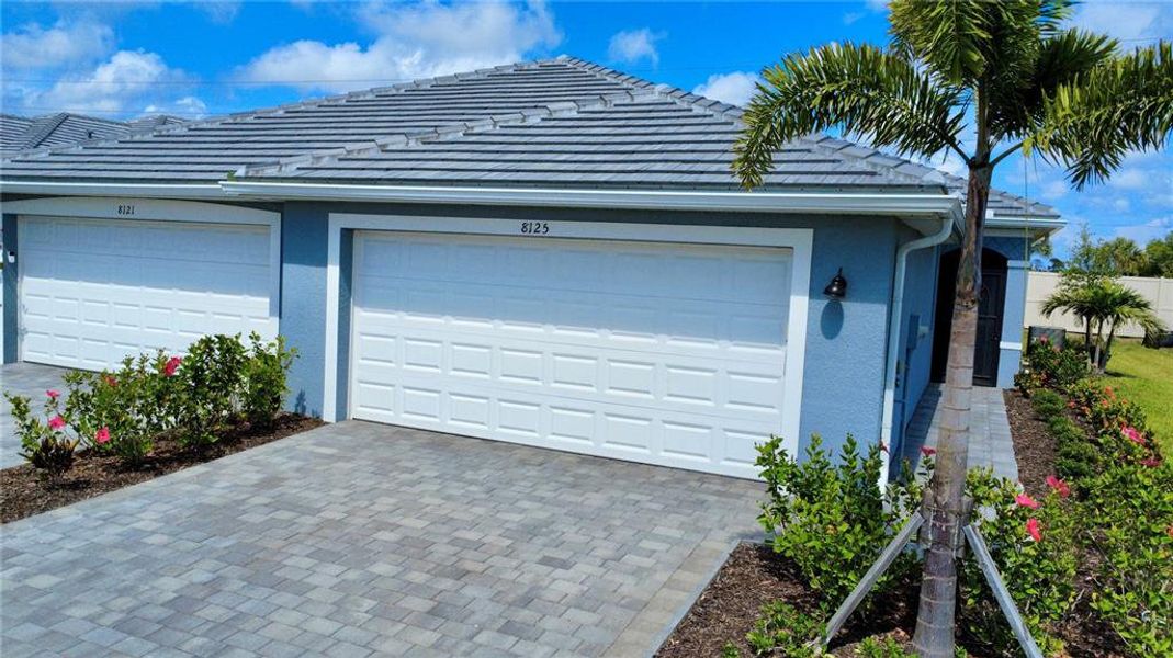 Front exterior of a new home in Palm Lake at Coco Bay, Englewood, FL, highlighting curb appeal (Image 19). Front exterior of a new home in Palm Lake at Coco Bay, Englewood, FL, highlighting curb appeal (Image 19).