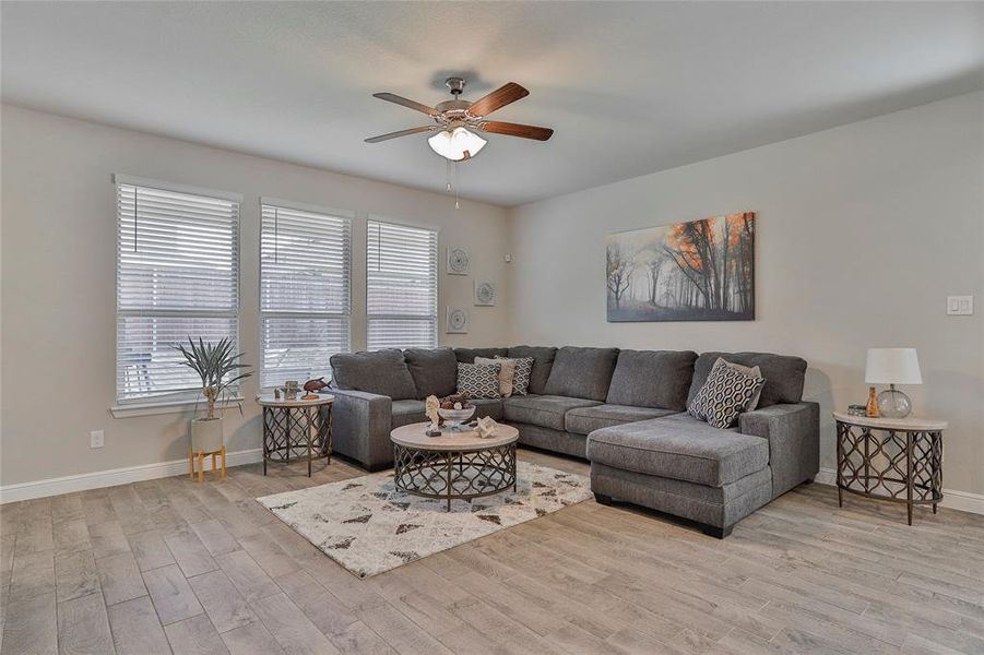Living area with ceiling fan and light wood finished floors Living area with ceiling fan and light wood finished floors
