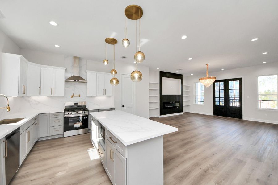 Stunning open-concept living and kitchen with oversized quartz island, designer lighting, and seamless flow to the balcony.