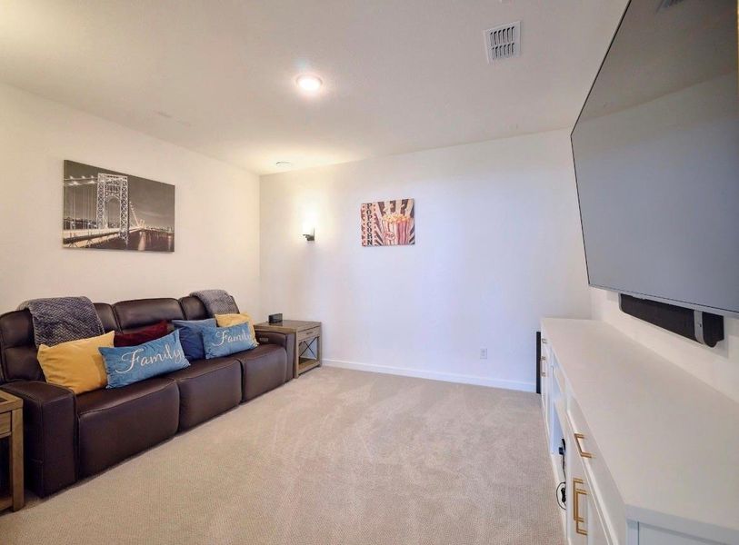Experience cinematic comfort in this movie room, featuring sleek custom cabinets.