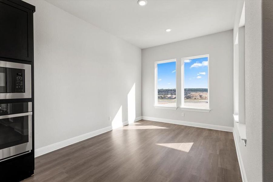 Empty room with dark wood-style floors and recessed lighting