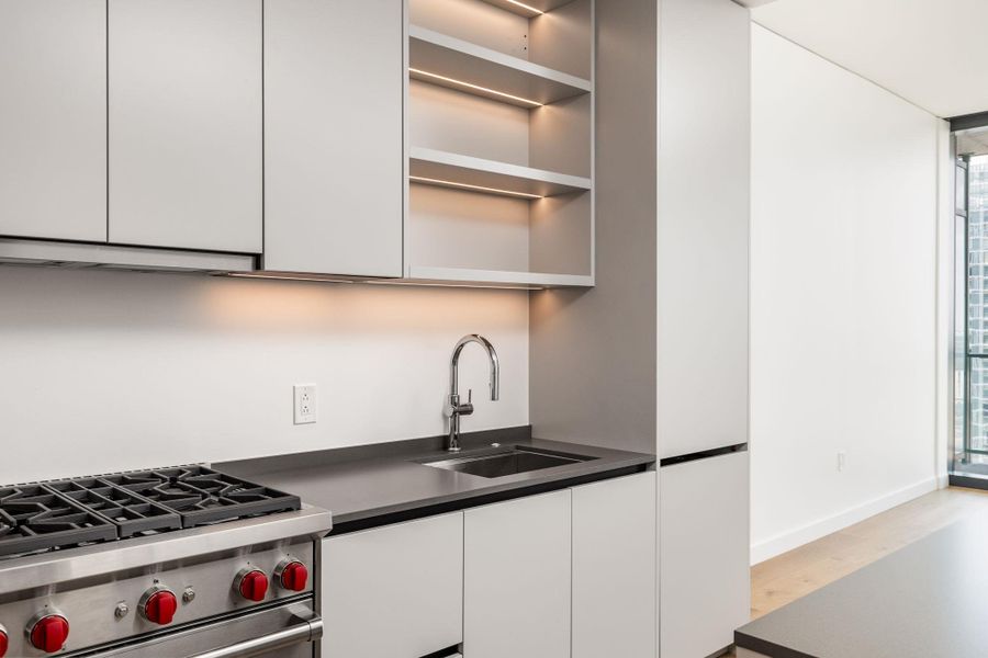 Modern kitchen with streamlined cabinetry, built-in appliances, and a gas range.