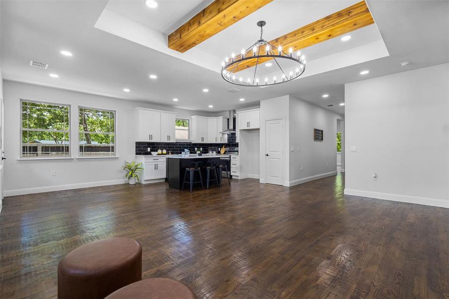 Living room with recessed lighting, a chandelier, dark wood-style floors, and beam ceiling Living room with recessed lighting, a chandelier, dark wood-style floors, and beam ceiling