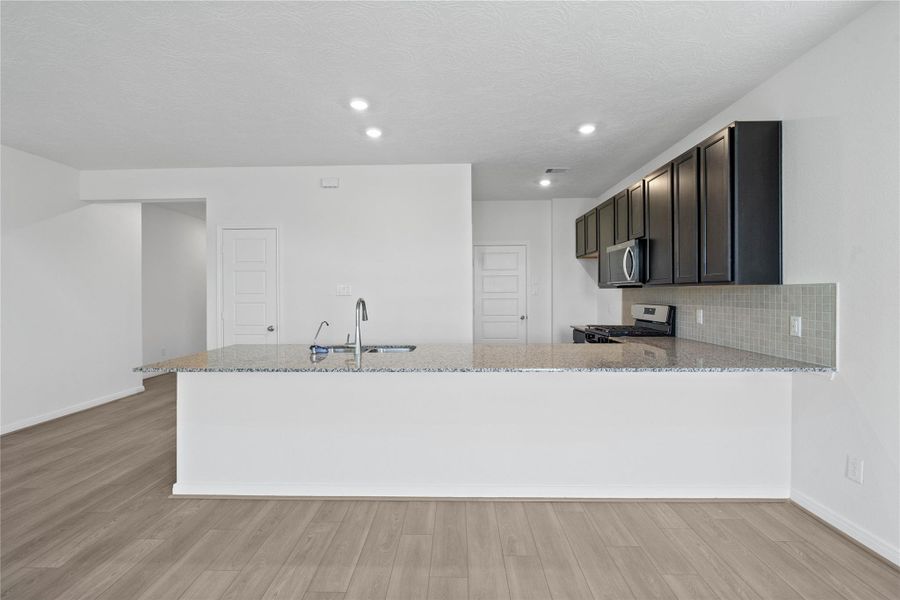 The extended breakfast bar provides additional seating—perfect for a quick meal—while keeping you connected to conversations in both the kitchen and dining area.