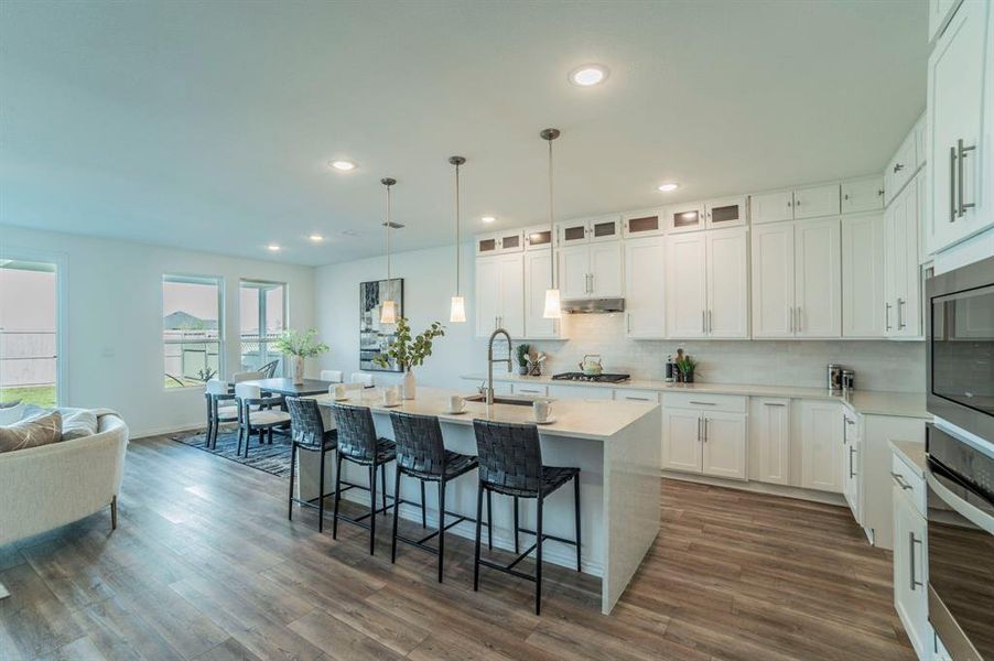 Kitchen with tasteful backsplash, stainless steel appliances, light stone counters, decorative light fixtures, and recessed lighting Kitchen with tasteful backsplash, stainless steel appliances, light stone counters, decorative light fixtures, and recessed lighting
