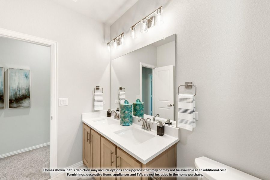 Bathroom with double-sink vanity, wood cabinets, white countertop, large mirror, and brushed nickel light fixture above.