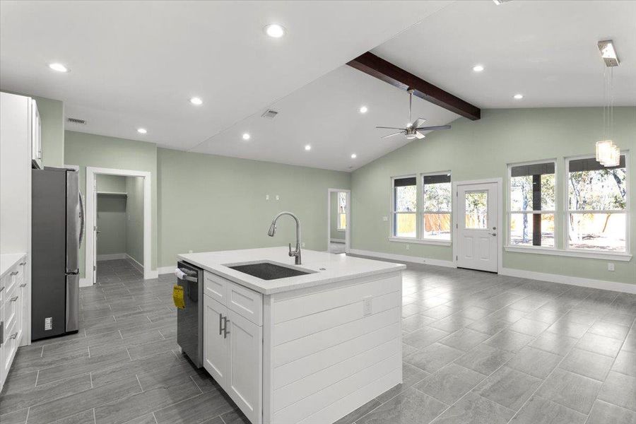 Kitchen with open floor plan, white cabinets, ceiling fan, appliances with stainless steel finishes, and recessed lighting