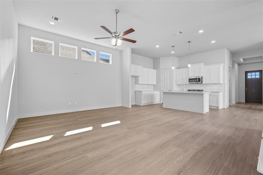 Unfurnished living room featuring light wood finished floors, recessed lighting, and ceiling fan