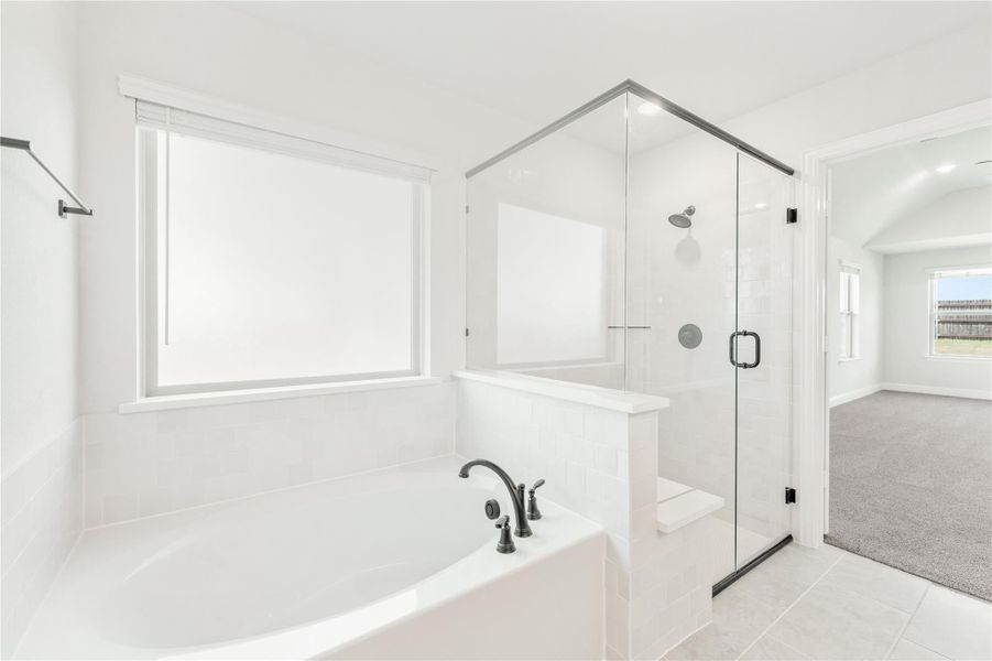 Master bathroom with soaking tub, glass-enclosed walk-in shower, and white tile floors