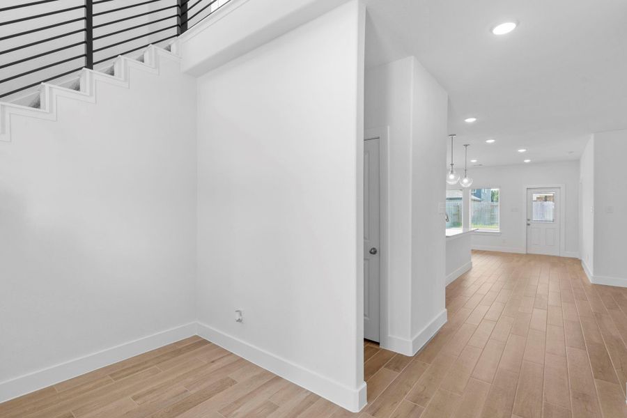Elegant sweeping staircase with modern cable railing, perfectly positioned off the grand entryway.