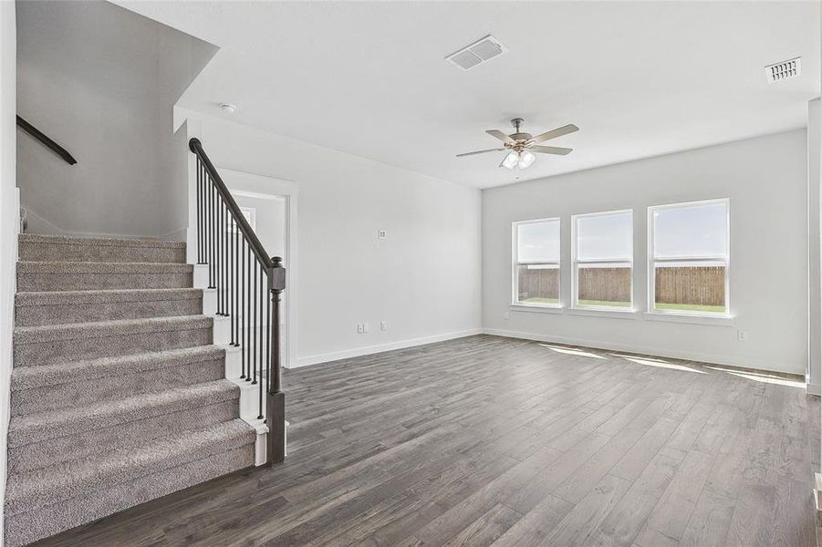 Unfurnished living room with ceiling fan and dark hardwood / wood-style flooring