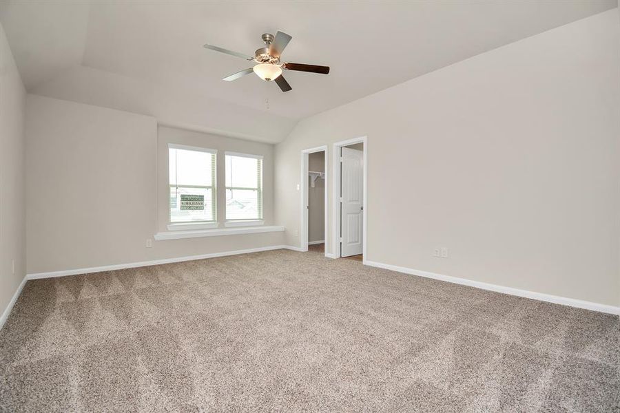 Drift off to sleep in this peaceful and spacious primary bedroom. The large windows bathe the room in natural light, while the ceiling fan provides a cooling breeze. This serene retreat is the perfect place to unwind and recharge after a long day. **This image is from another Saratoga Home with similar floor plan and finishes, not the Brittany floorplan.**