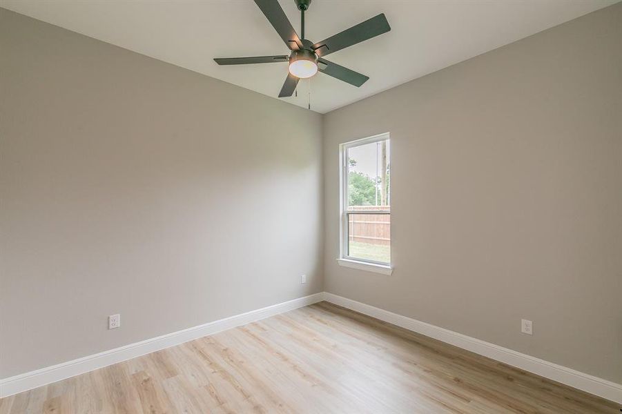 Unfurnished room featuring light wood finished floors, baseboards, and ceiling fan Unfurnished room featuring light wood finished floors, baseboards, and ceiling fan