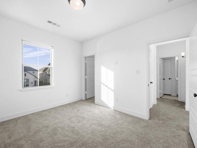 Unfurnished bedroom featuring light colored carpet and baseboards Unfurnished bedroom featuring light colored carpet and baseboards