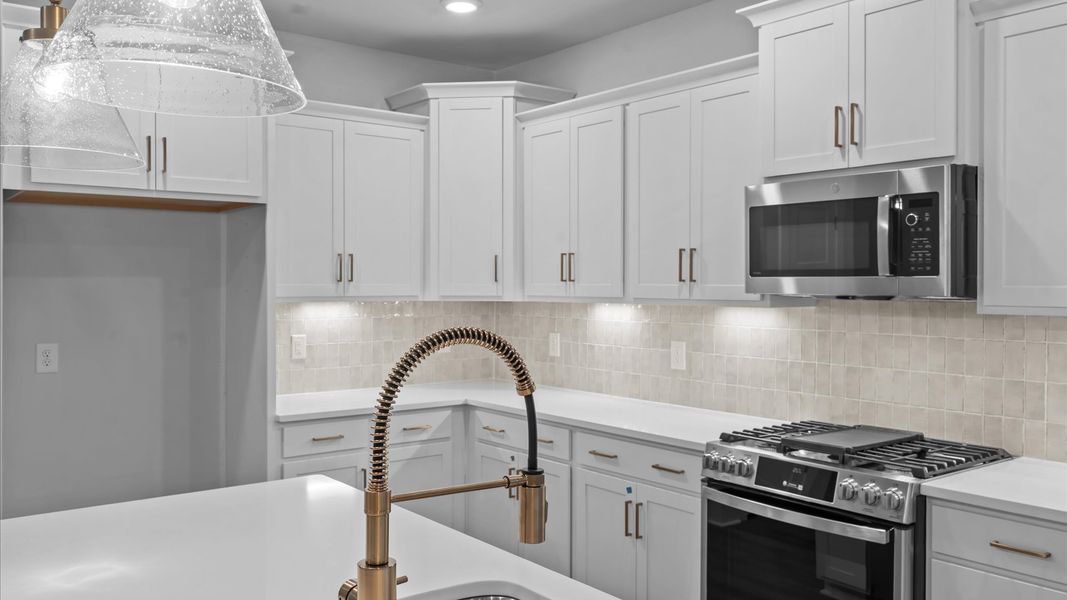 Elegant kitchen featuring a 9-foot island with pendant lighting and tasteful finishes throughout Elegant kitchen featuring a 9-foot island with pendant lighting and tasteful finishes throughout