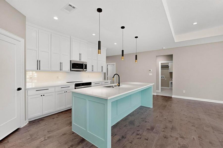 Kitchen with white cabinets, hanging light fixtures, decorative backsplash, dark wood-type flooring, and recessed lighting Kitchen with white cabinets, hanging light fixtures, decorative backsplash, dark wood-type flooring, and recessed lighting