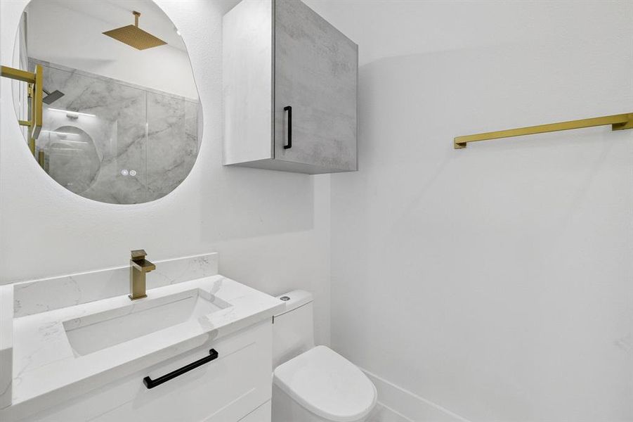 Full bathroom featuring a marble finish shower and vanity