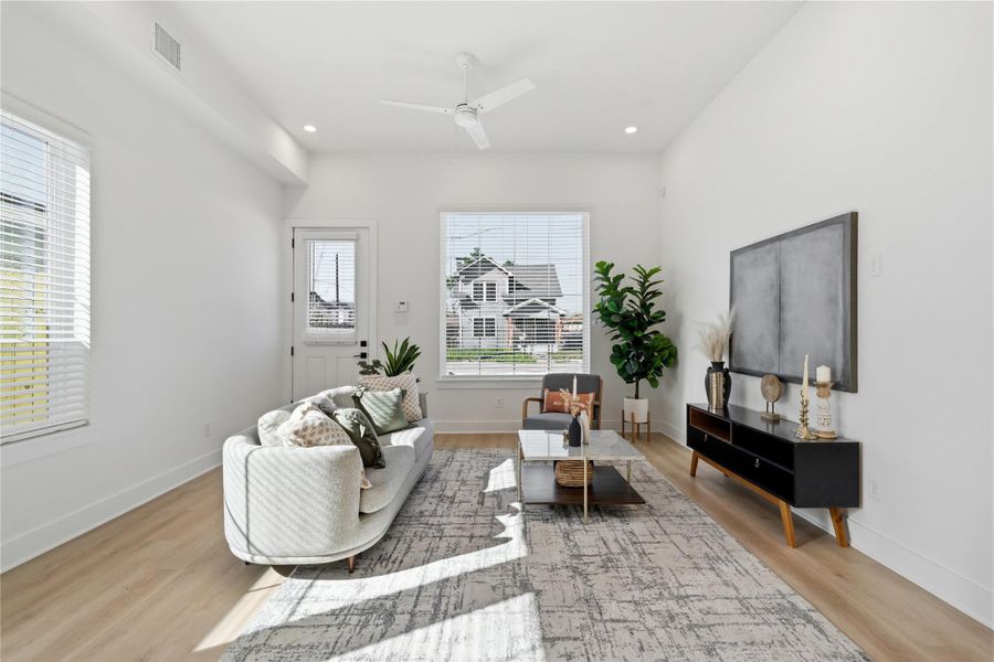 Bright duplex living area with 11’ ceilings, oversized windows, and abundant natural light throughout.