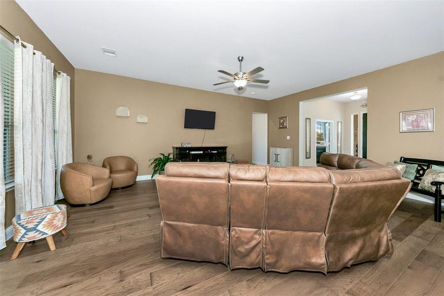 Living room with wood-type flooring and ceiling fan