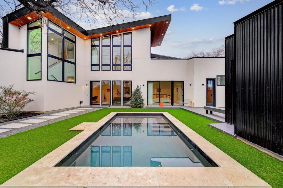 Back of house featuring a patio, stucco siding, an outdoor pool, and a yard