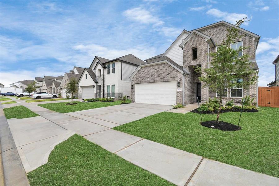 The residence features a practical 2-car garage complemented by a generous driveway, ensuring abundant space for parking needs.