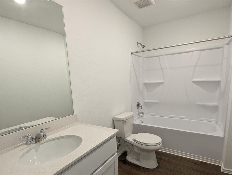 A well-appointed bathroom features a sleek vanity and a pristine tub-shower combination.