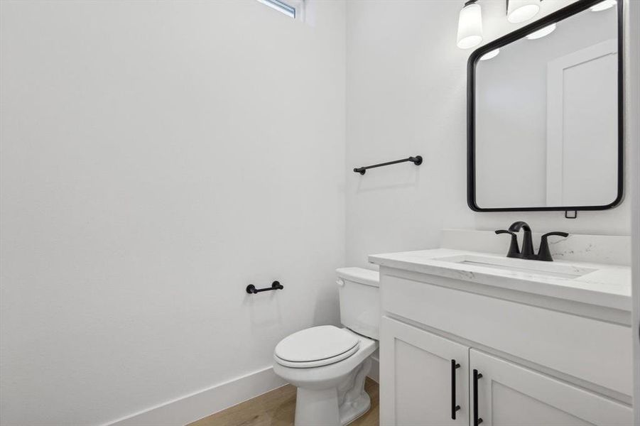 Bathroom with hardwood / wood-style flooring, vanity, and toilet