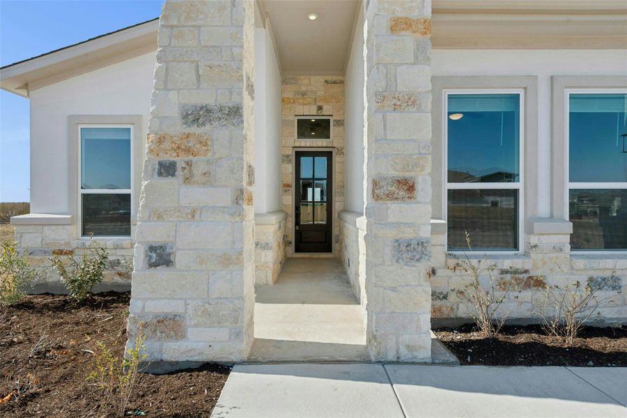 Entrance to property featuring stone siding