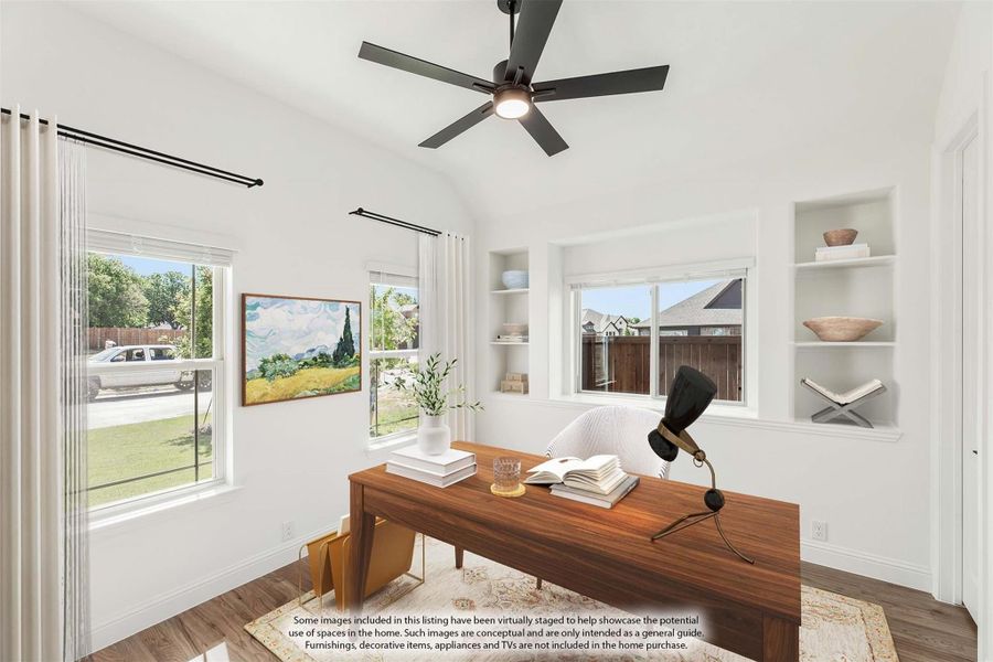 Home office with wood desk, built-in shelves, ceiling fan, and vaulted ceiling with multiple windows